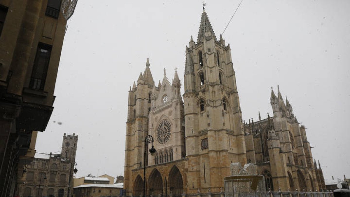 Gente junto a la Catedral de León este sábado, durante la nevada. FERNANDO OTERO
