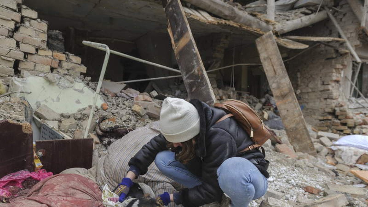 Una niña rescata a un perro de los escombros de un edificio atacado en Lviv. MYKOLA TYS