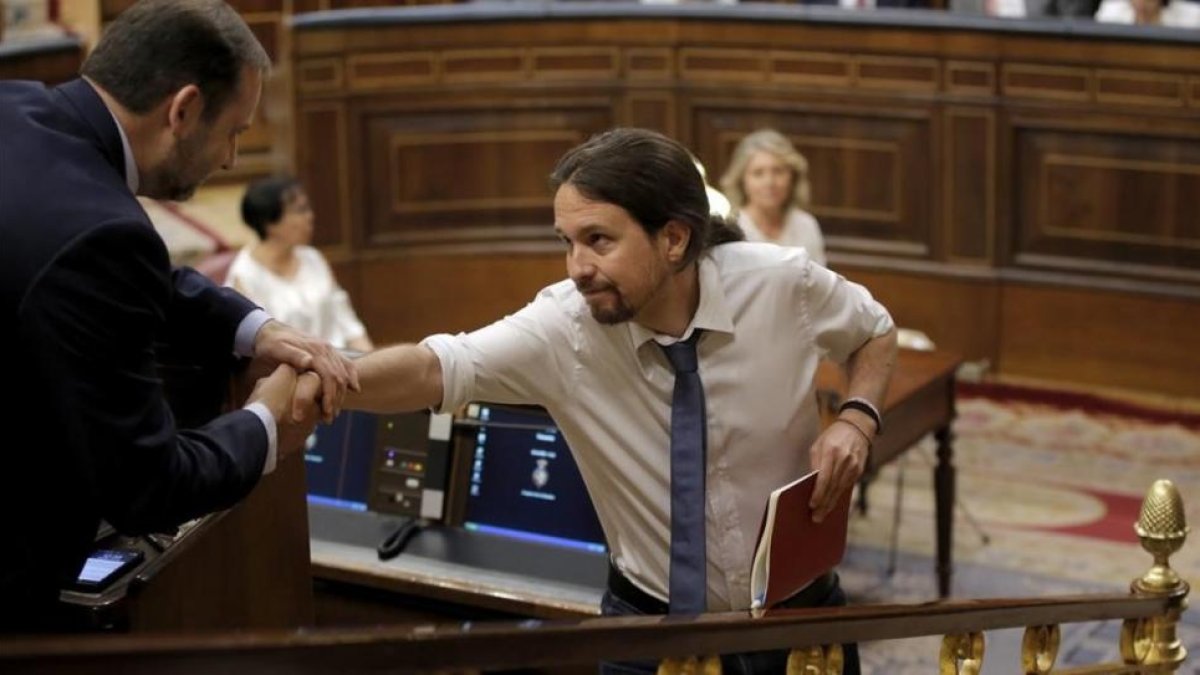 Iglesias se acerca a saludar a Ábalos en el debate de moción de censura.