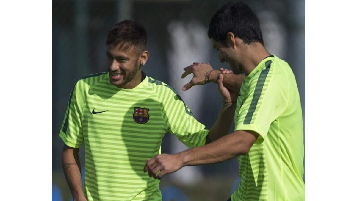 Neymar bromea con Luis Suárez durante el entrenamiento de ayer.