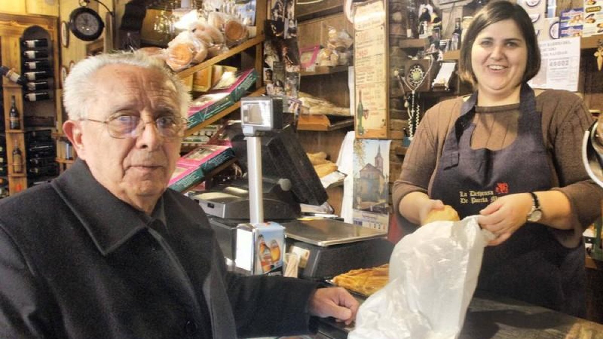 Enrique García Centeno, párroco de la iglesia del Mercado, comprando en la tienda de Irene. DL