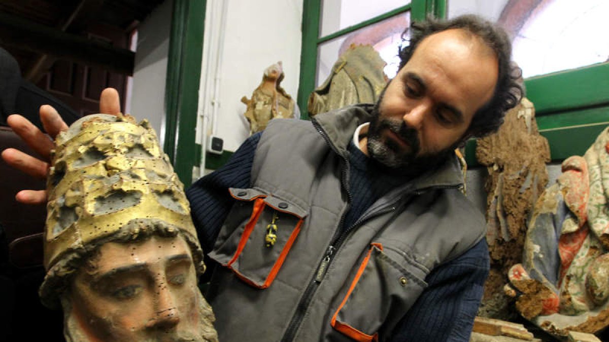 Un trabajador del Centro de Restauración y Conservación, con la cabeza de una talla.
