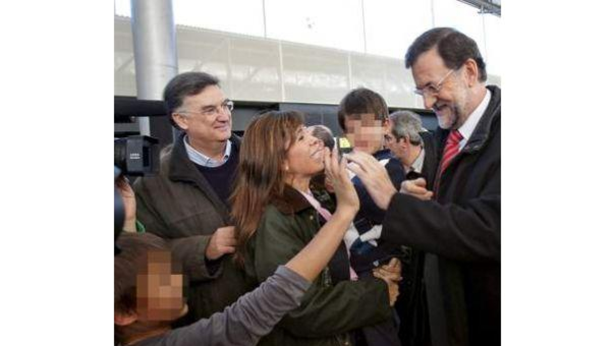 Rajoy saluda a un niño observado por Sánchez-Camacho.