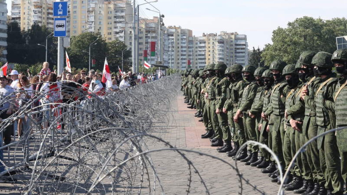 Los manifestantes se encaran a la policía tras la alambrada. STRINGER