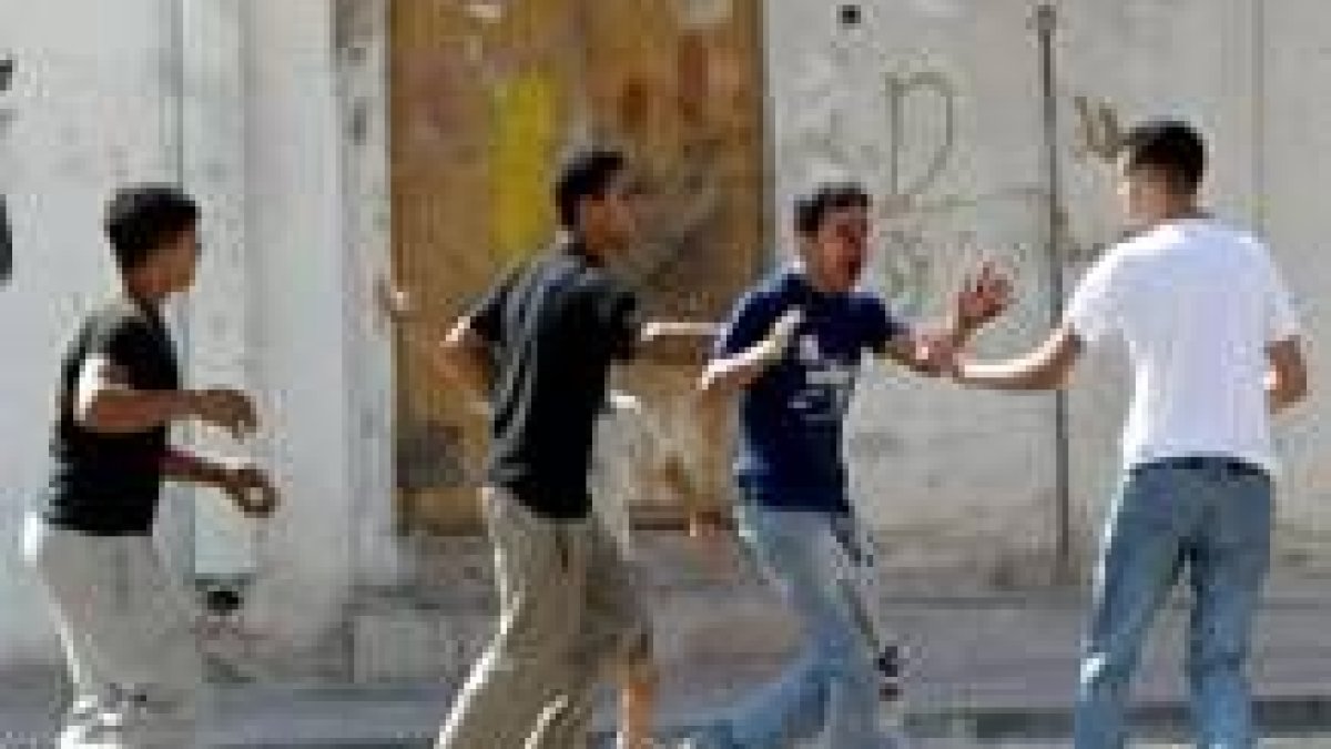 Unos jóvenes ayudan a otro palestino después de que recibiera un tiro en la cara en Askara