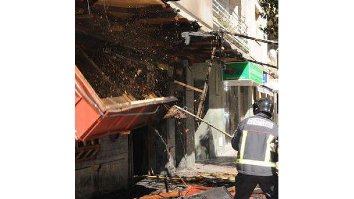 Un bombero tira la marquesina del local de alterne antes de que se derrumbe.