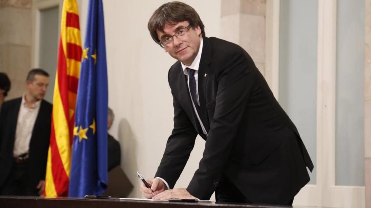 El president Carles Puigdemont en el momento de firmar la declaración, tras el pleno