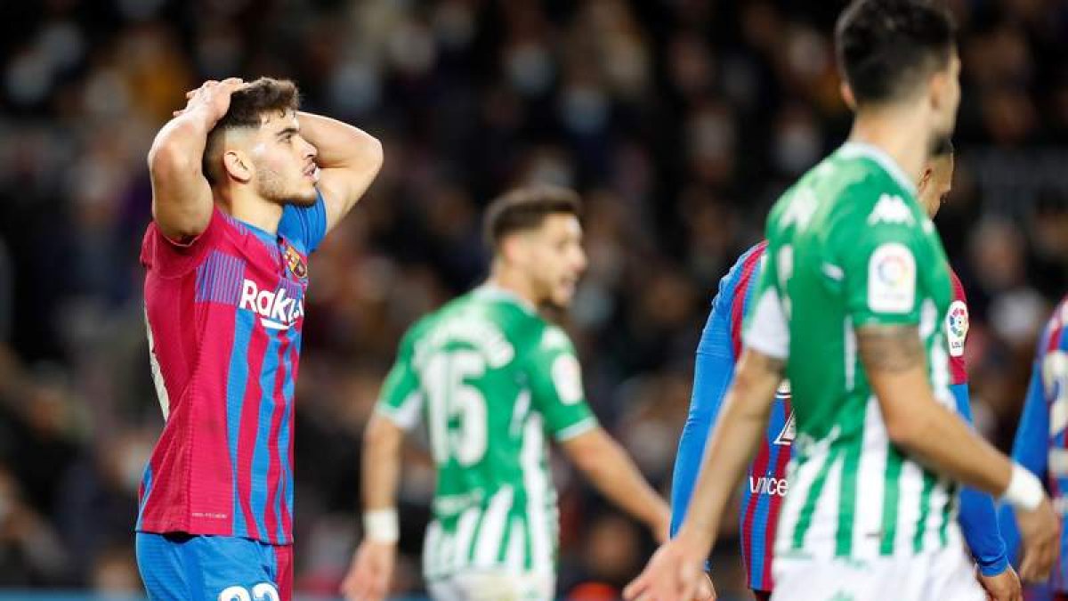 Abdessamad Ezzalzouli se lamenta tras el gol del centrocampista del Betis Juanmi durante el partido de Liga en el Camp Nou. ALBERTO ESTÉVEZ