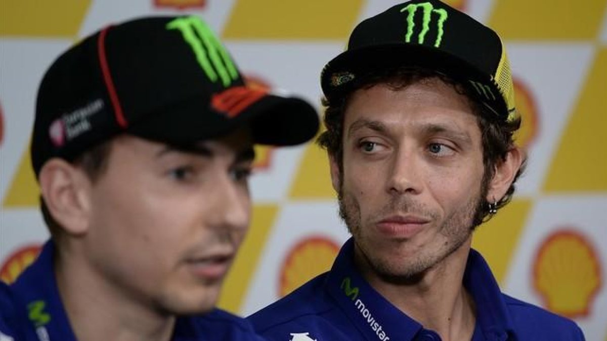 El piloto italiano Valentino Rossi escuchando las declaraciones de su compañero de equipo Jorge Lorenzo.