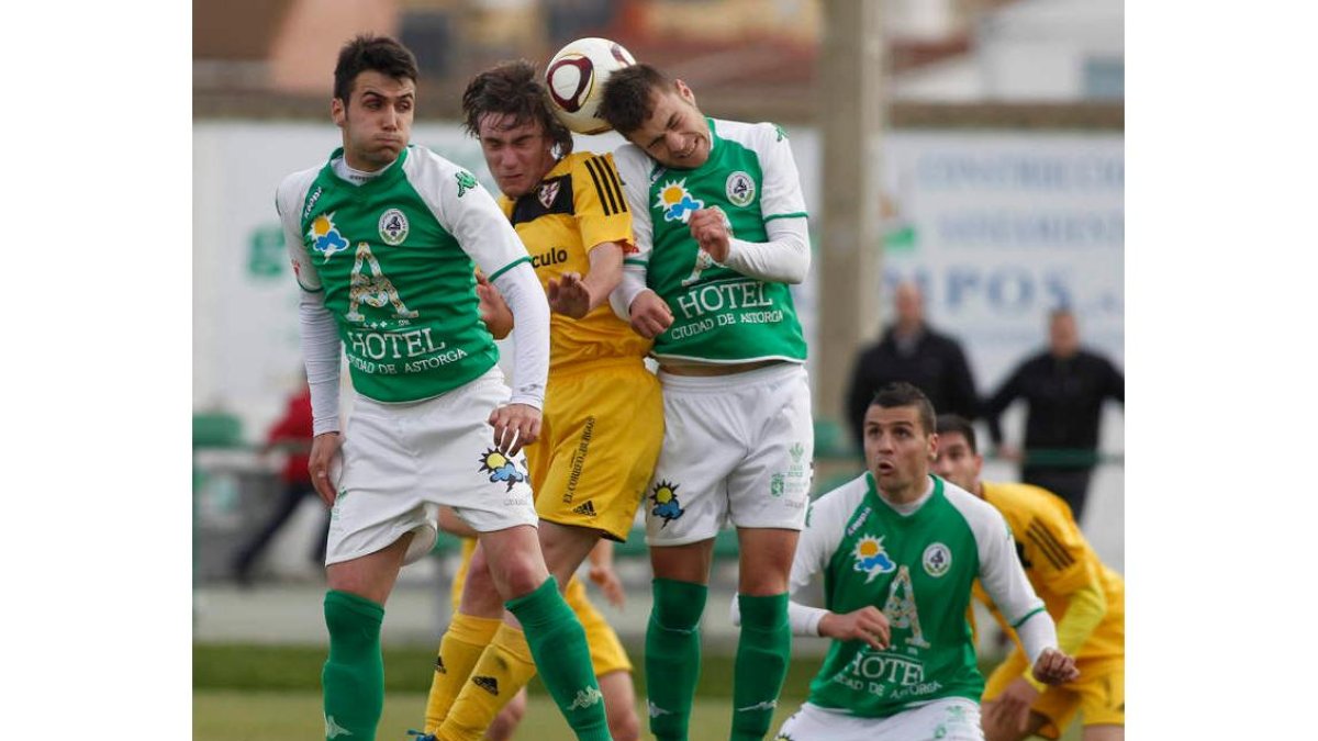 Rubén y Cristian evitan el remate de un jugador burgalés.