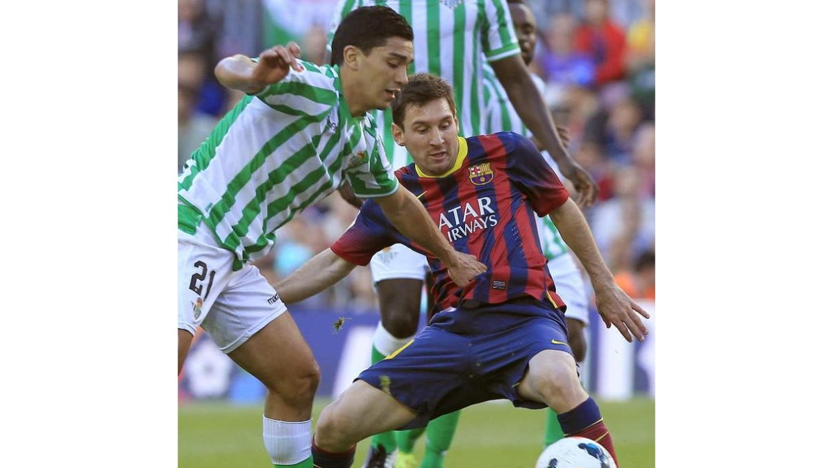 Reyes intenta quitarle el balón a Messi, bigoleador del Barça.