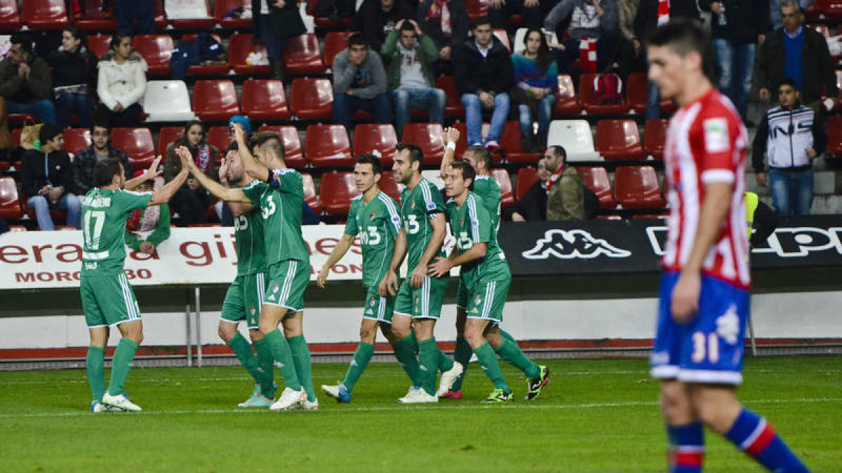 Los jugadores de la Deportiva celebran el tanto de Nano que dio la victoria al equipo berciano ante la consternación del central Borja López y la desesperación de los aficionados esportinguistas del Molinón.