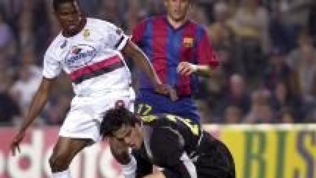 El guardameta Víctor Valdés recupera un balón ante el delantero mallorquinista Eto'o