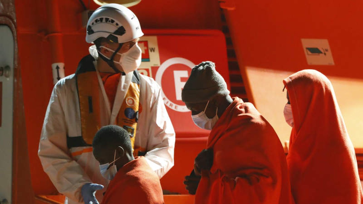 Un miembro del equipo de salvamento ayuda a un niño que llegó en una de las pateras. ELVIRA URQUIJO A.