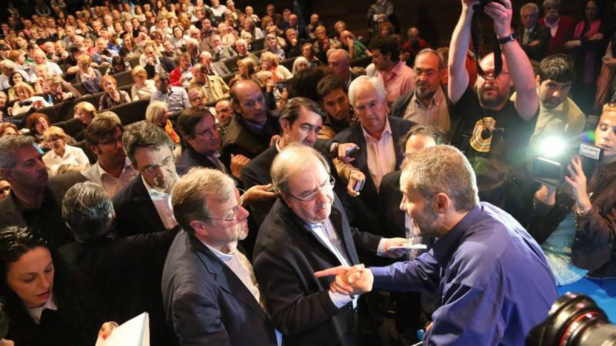 Herrera y Silván habla con uno de los mineros durante el mitin del PP