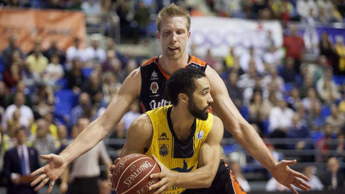Justin Hamilton, del Valencia Basket, trata de frenar al base del Iberostar Tenerife, White.