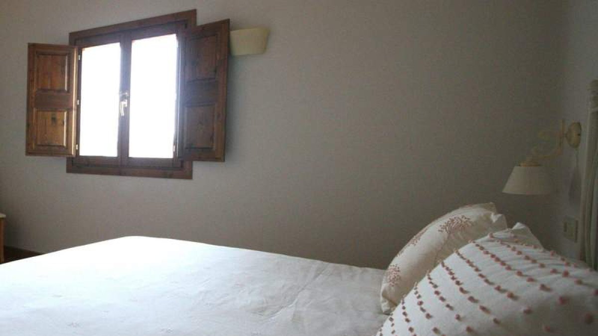 Blanco y madera en habitaciones y estancias invitan al relax en El Barreal, en Quintana Raneros.