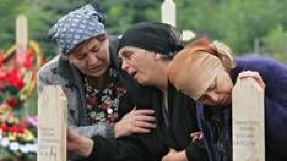 Tres mujeres lloran en el cementerio de Beslan