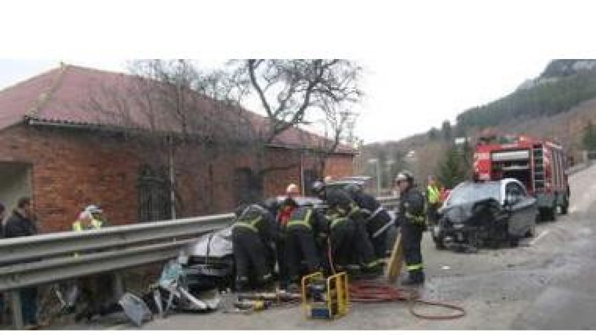 Efectivos del cuerpo de Bomberos tratan de excarcelar a uno de los heridos.