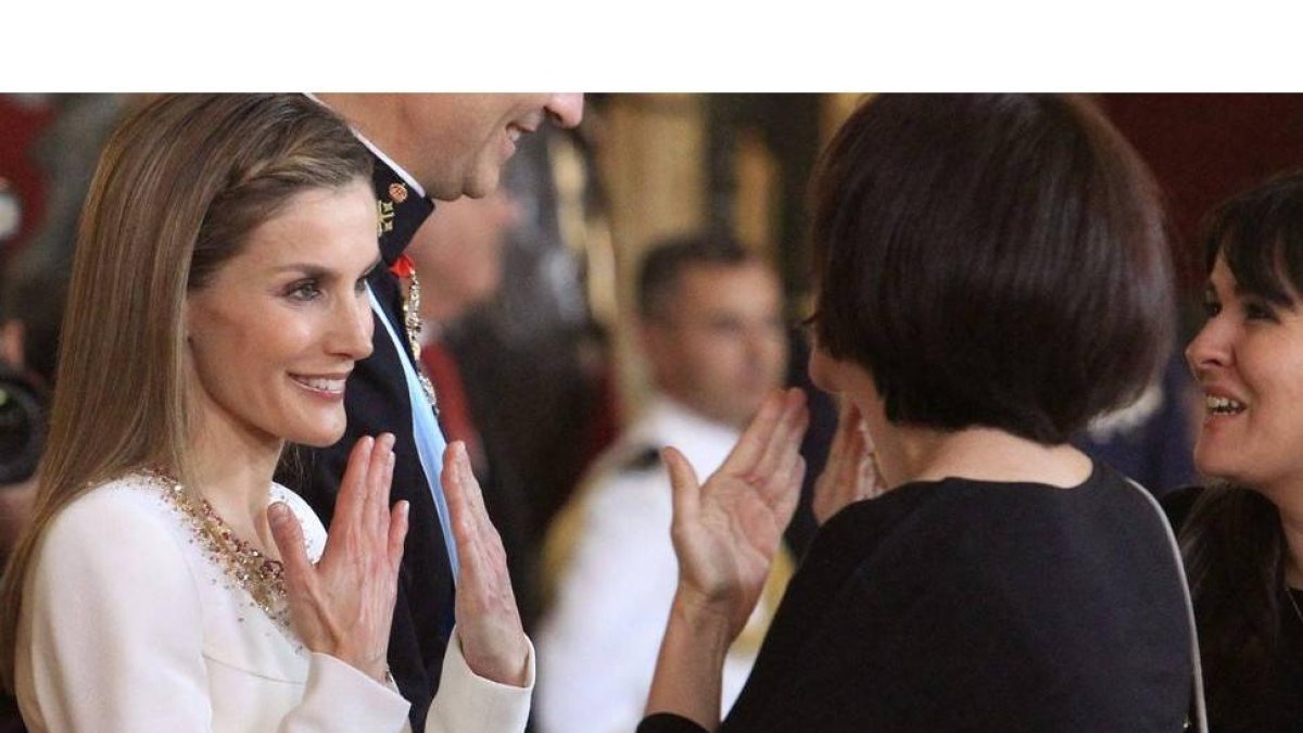Doña Letizia habla en lengua de signos con una invitada durante la recepción a los representantes instucionales en el Palacio Real con motivo de la proclamación del rey