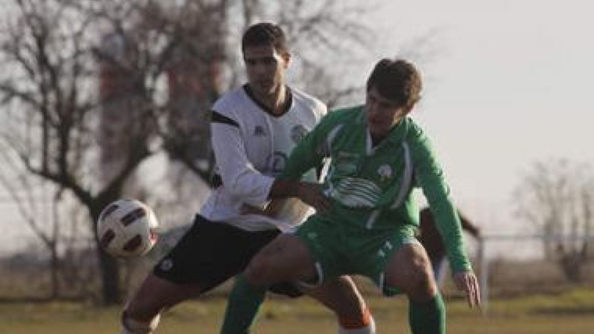 Alfonso, a la derecha, forcejea para hacerse con el balón.