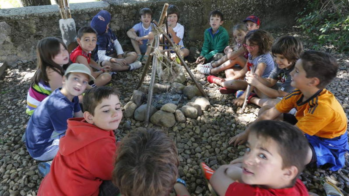 Varios de los niños que participan en las actividades de la fundación se sientan en torno a una hoguera, en uno de los talleres que realizaron ayer.