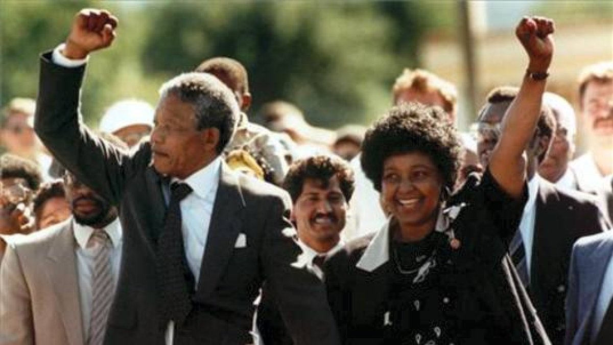 Nelson Mandela saluda a la multitud, acompañado por su entonces esposa Winnie, al salir de la cárcel el 11 de febrero de 1990 en Ciudad del Cabo.