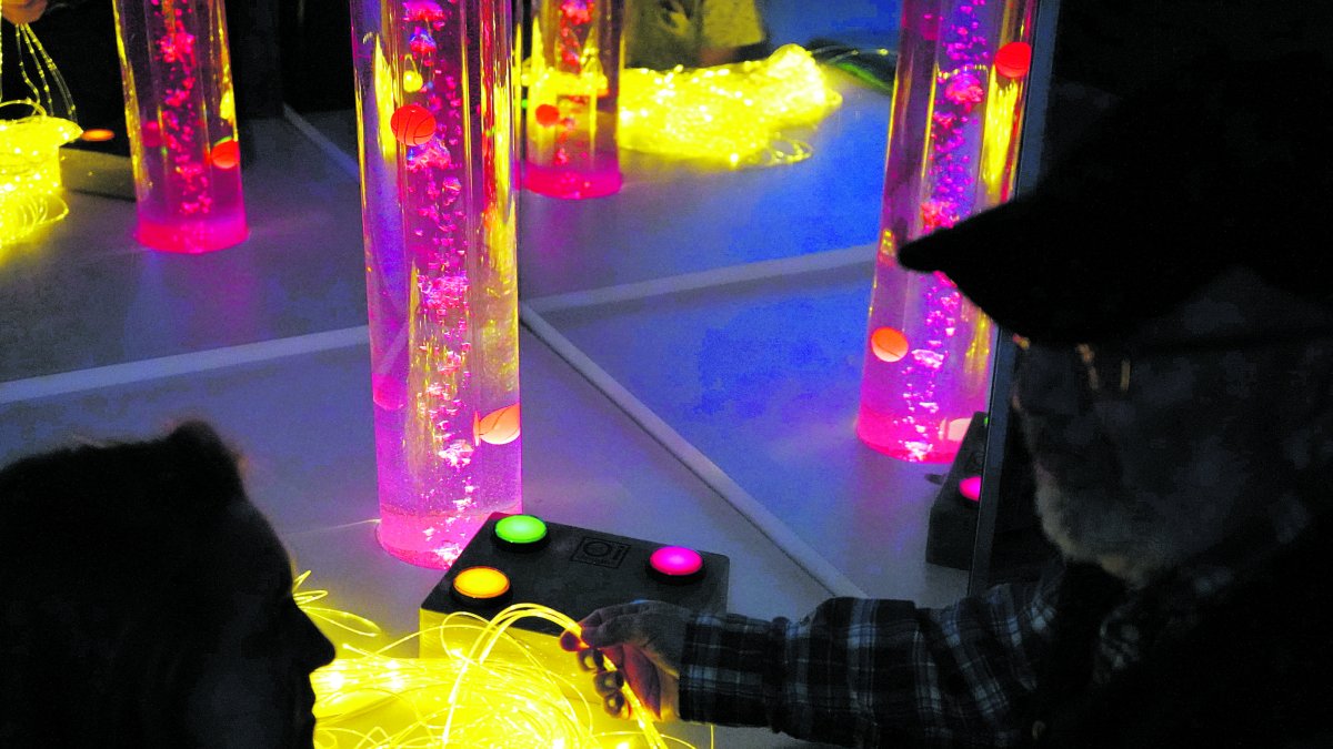 Haces de luz de colores y tubos de burbujas para estimular los sentidos en una sala Snoexelen en el Centro Alhéimer de León. J. NOTARIO
