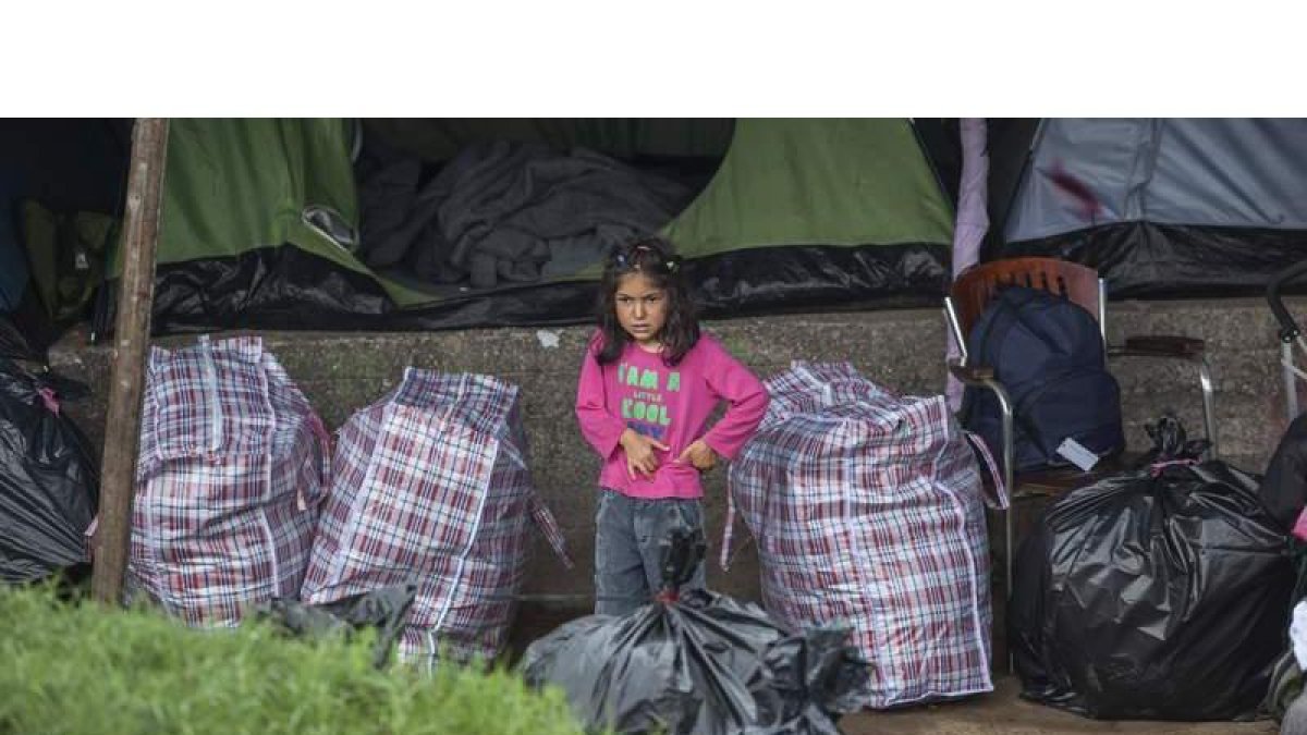 Una niña espera junto a su tienda a ser trasladada en Grecia. NIKOS ARVANITIDIS / POOL