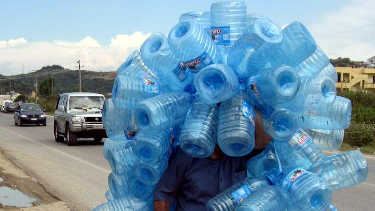 Un hombre porta envases de plástico. efe