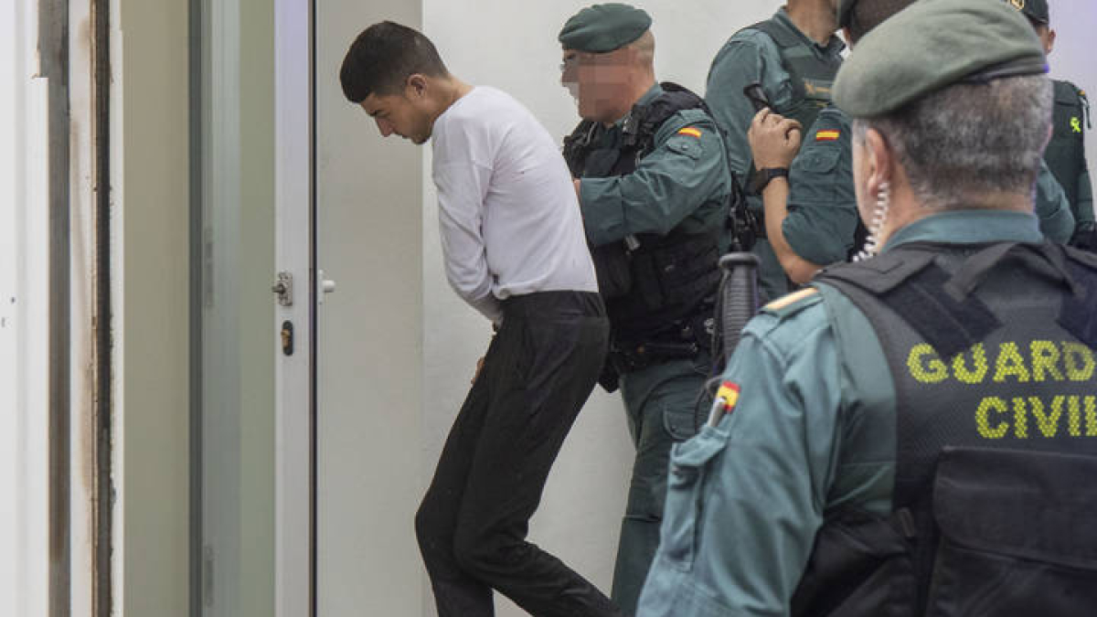 Agentes de la Guardia Civil trasladan a los juzgados de Barbate (Cádiz) a uno de los ocho detenidos por la muerte de dos guardias civiles a los que arrollaron con una narcolancha en la localidad gaditana de Barbate el pasado viernes, que este lunes han pasado a disposición judicial.