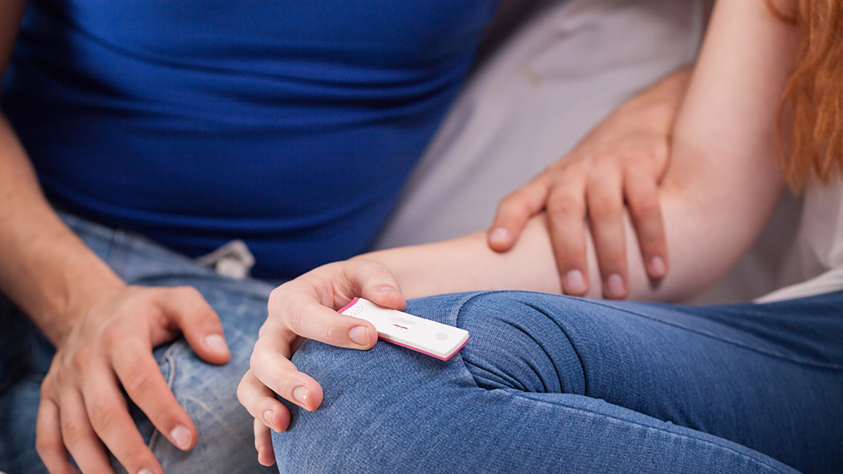 Pareja utilizando un test de embarazo.