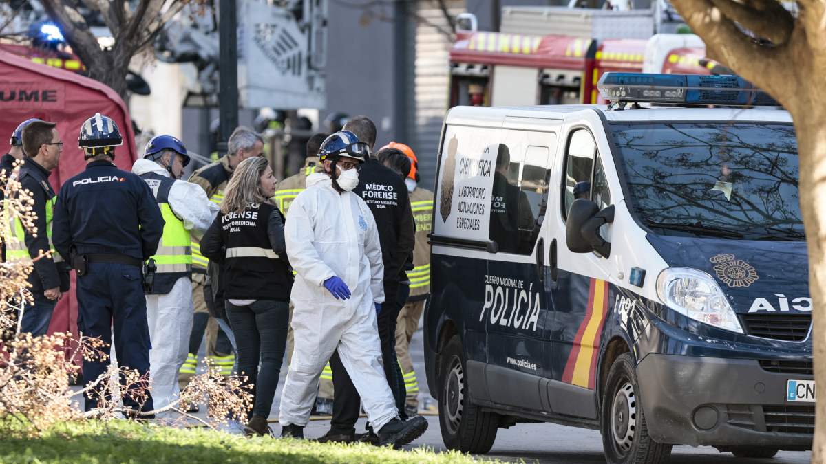 Agentes de la Policía Científica y técnicos y médicos forenses en los alrededores del edificio incendiado.