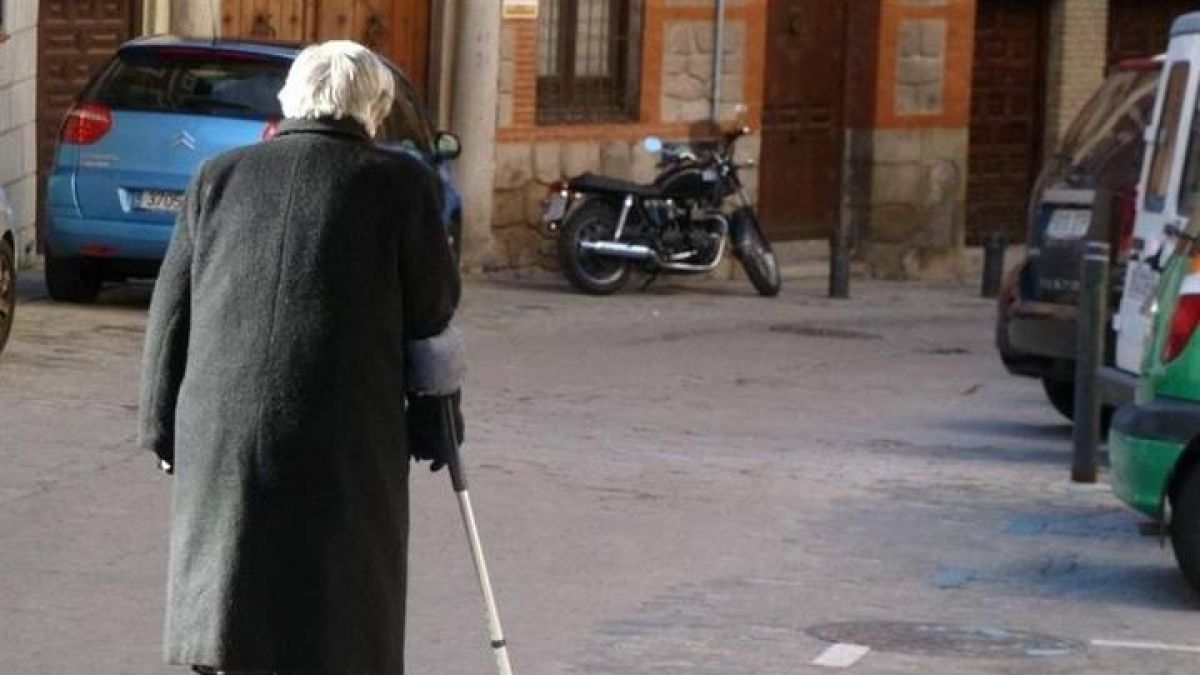 Un anciano pasea por la calle.