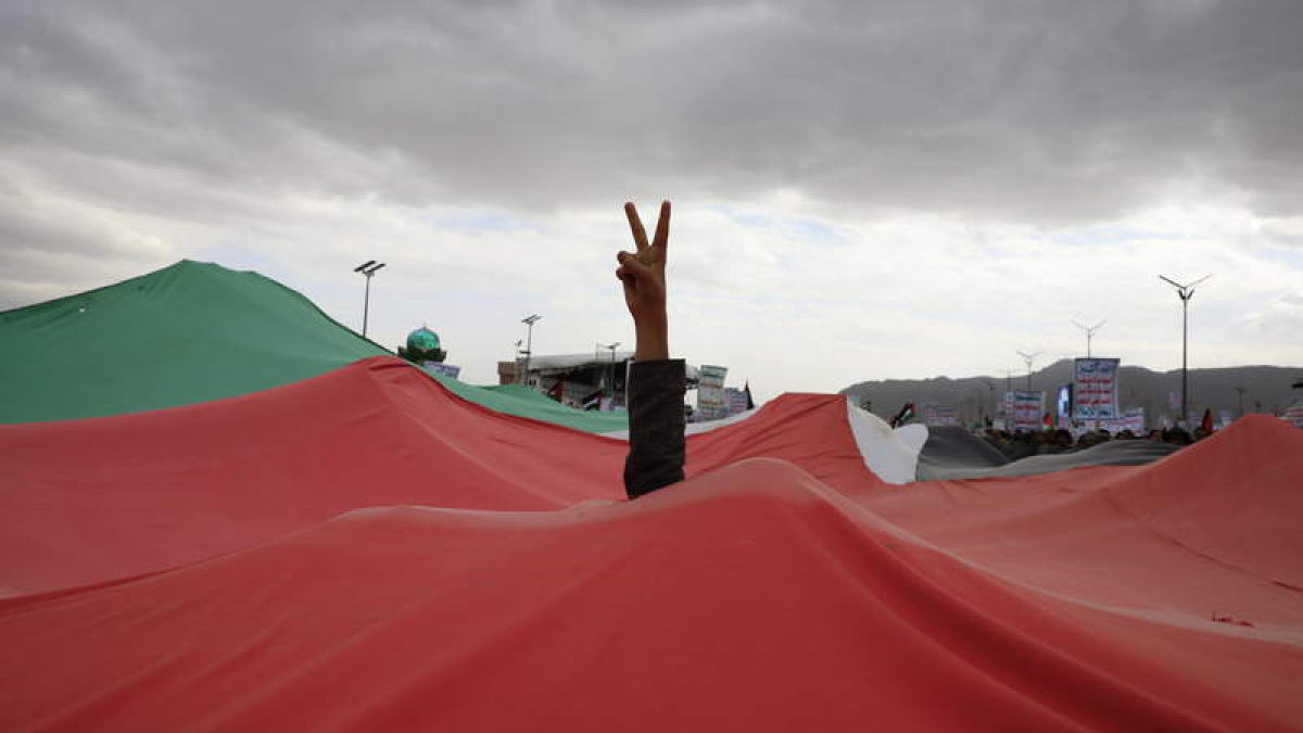 Un hutíe realiza un símbolo de la victoria sobre una bandera palestina.  YAHYA ARHAB