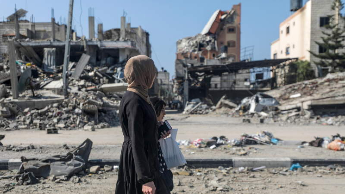 Palestinos pasan frente a un barrio destruido en Gaza. MOHAMMED SABER