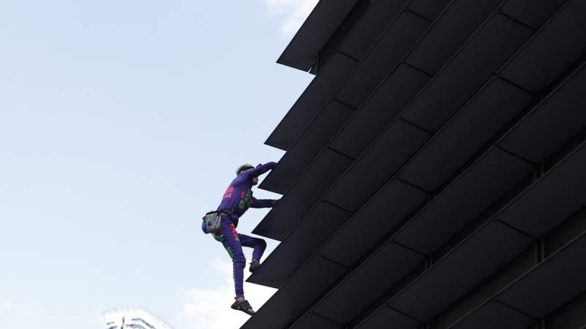 Alain Robert escala, sin arnés ni cuerdas, un rascacielos en Manila.   FRANCIS R. MALASIG