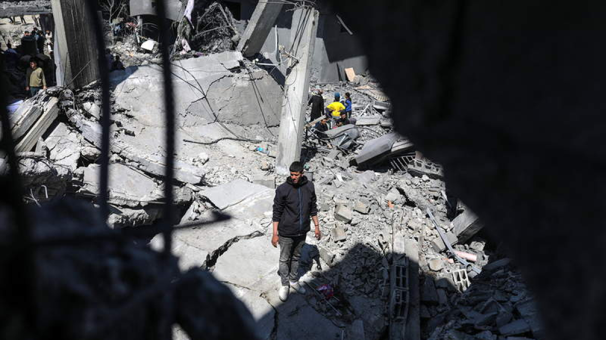 Palestinos buscando supervivientes entre los escombros de una casa.  MOHAMMED SABER