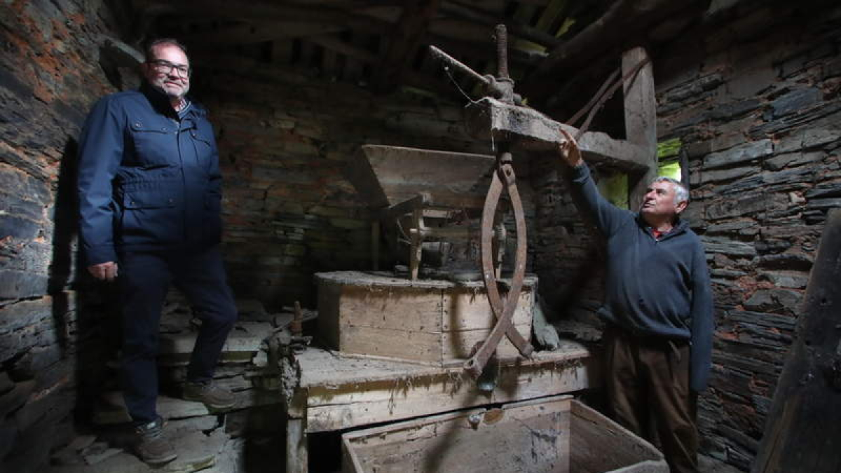 El alcalde de Arganza, Javier Ovalle, y el pedáneo de Espanillo,  el exminero de la MSP Alfredo Lago, en el interior del molino harinero del pueblo.  L. DE LA MATA