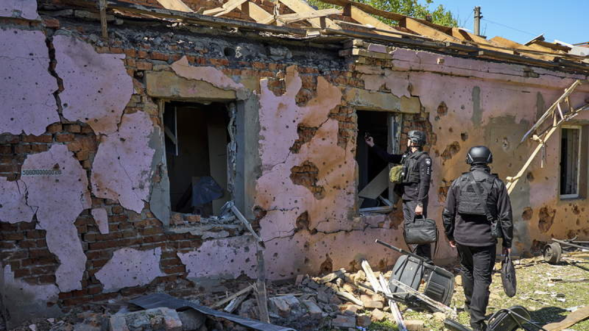 Los expertos examinan una casa afectada por un ataque ruso en Kharkiv, Ucrania.  SERGEY KOZLOV
