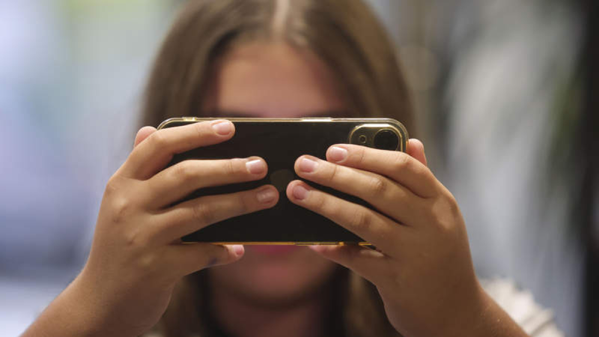 Una chica consulta su teléfono móvil.  DL