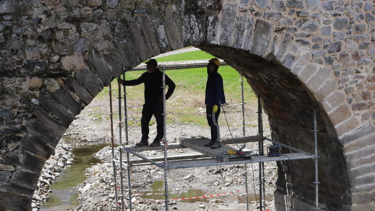 Operarios en las tareas de limpieza y rejuntado debajo de uno de los arcos del puente.  ANA F. BARREDO