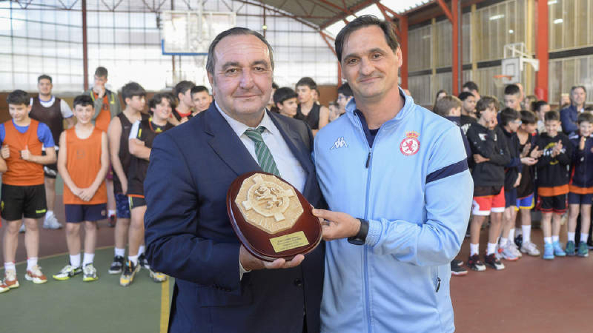 El director del Colegio Leonés, Manuel Belinchón, homenajea al entrenador Luis Castillo. MARÍA FUENTES