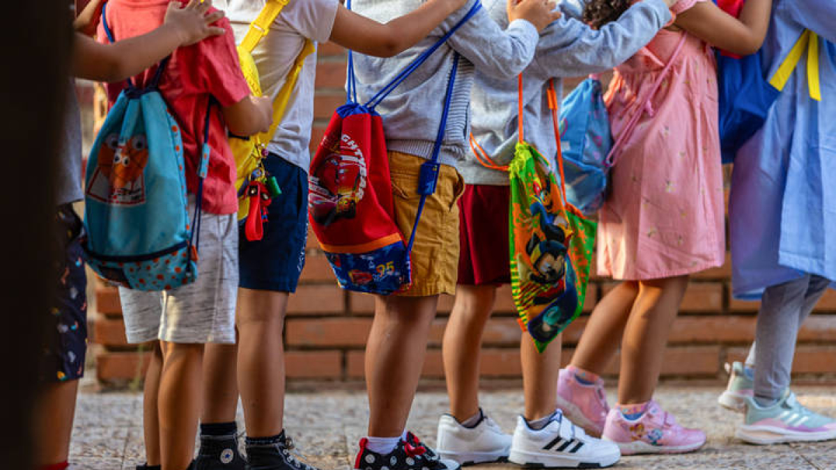 Niños y niás a la puerta de un colegio.