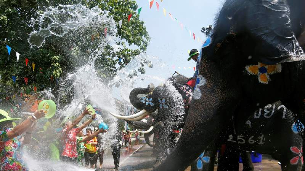 Elefantes y humanos se lanzan agua en un festival en Tailandia. RUNGROJ YONGRIT