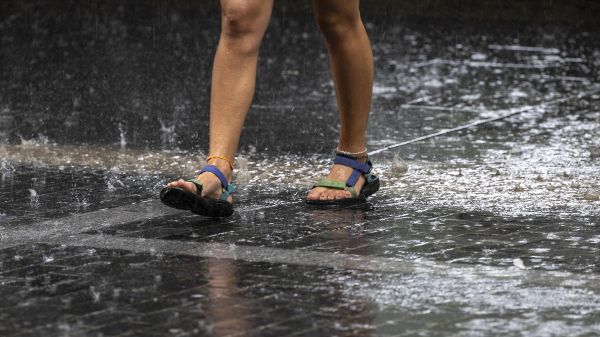 Una turista camina bajo la lluvia este martes en San Sebastián. EFE/Javier Etxezarreta