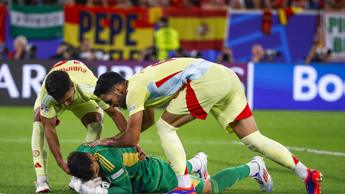 Los jugadores de la selección española, Mikel Merino (d) y Martín Zubimendi (i) felicitan a su compañero, el guardameta David Raya. Alberto Estévez