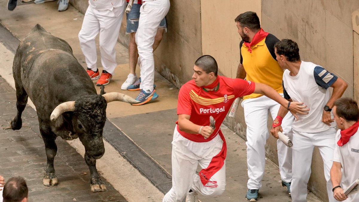 Los mozos perseguidos por los toros de la ganadería sevillana de Miura durante el último encierro de los Sanfermines 2024, este domingo, en Pamplona. EFE/Sergio Martín