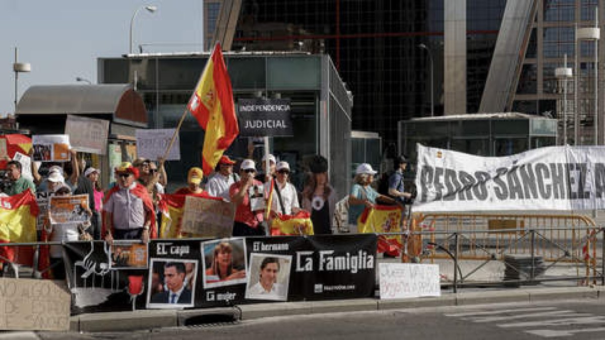 Un grupo de personas protesta en las inmediaciones de los juzgados de Plaza de Castilla de Madrid donde Begoña Gómez acudió a declarar.  ZIPI ARAGÓN