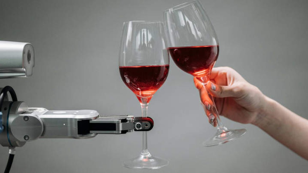 Brindis con vino entre humano y máquina.